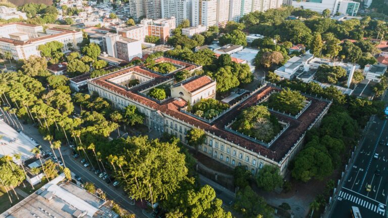 Stunning aerial view of a historic university amid lush greenery in Rio de Janeiro.