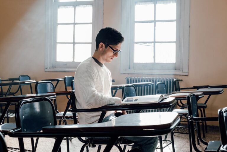 A student reading a book in a sunlit Buenos Aires classroom, reflecting focused learning.